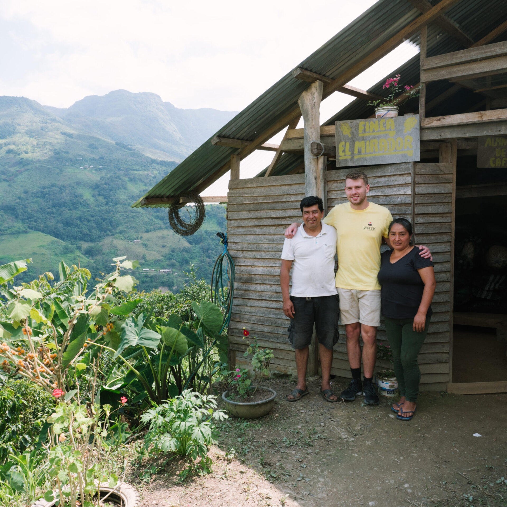 Carmen Herrera, Rasmus Ditlev, og Edis Herrera står ved deres kaffegård Finca El Mirador i Peru med flot udsigt over bjergene
